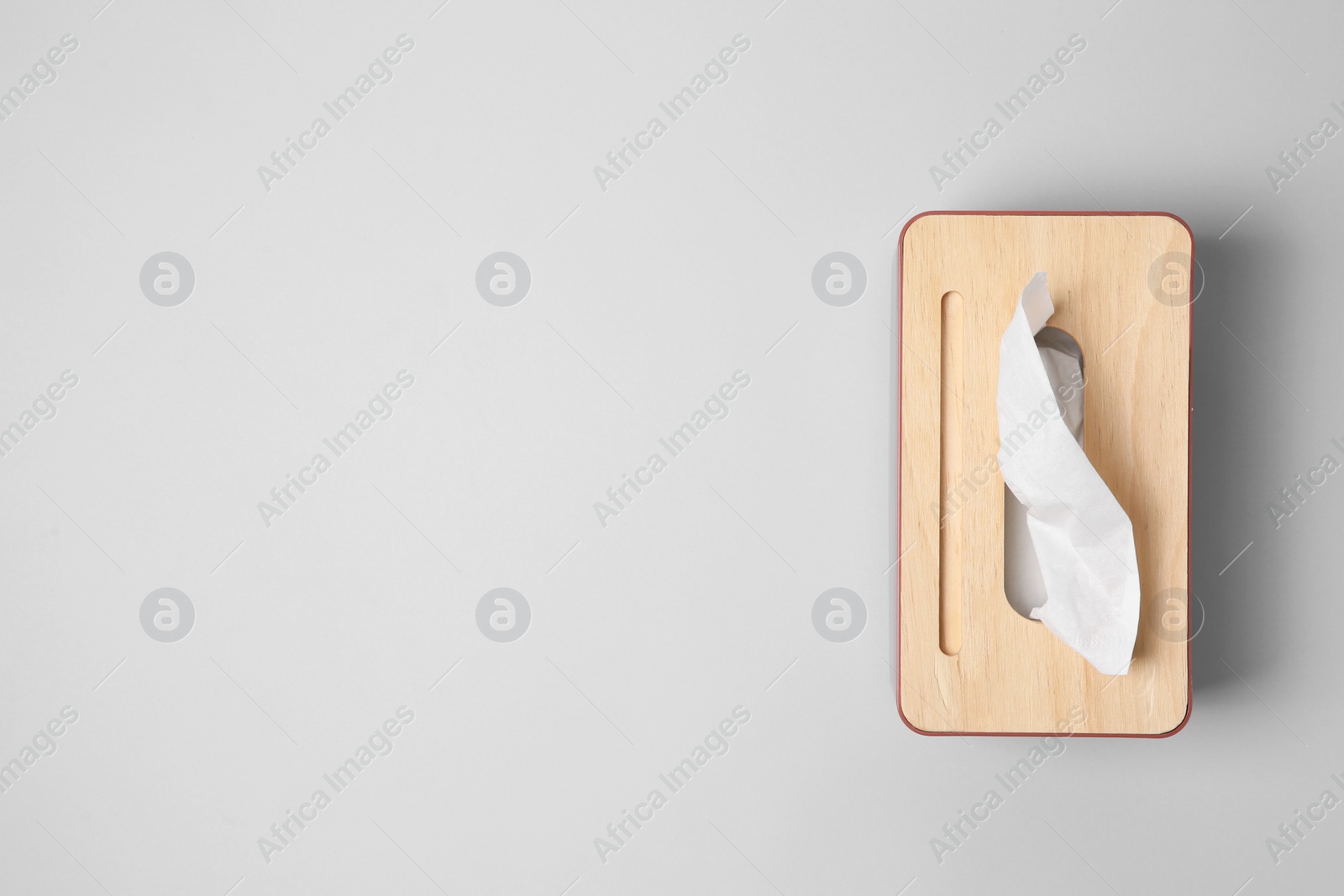 Holder with paper tissues on light grey background, top view. Space for text Photo of Holder with paper tissues on light grey background, top view. Space for text