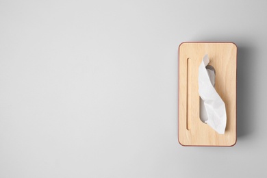 Holder with paper tissues on light grey background, top view. Space for text Photo of Holder with paper tissues on light grey background, top view. Space for text