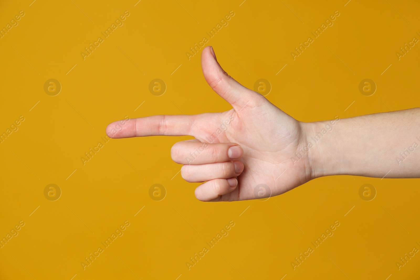 Woman pointing at something on yellow background, closeup. Finger gesture Photo of Woman pointing at something on yellow background, closeup. Finger gesture