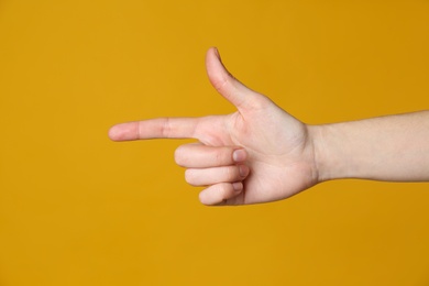 Woman pointing at something on yellow background, closeup. Finger gesture Photo of Woman pointing at something on yellow background, closeup. Finger gesture