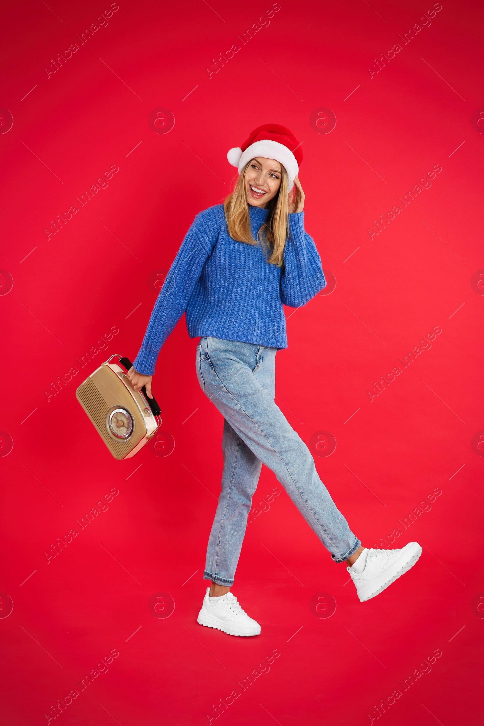 Happy woman with vintage radio on red background. Christmas music Photo of Happy woman with vintage radio on red background. Christmas music