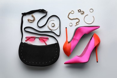 Stylish woman's bag, shoes, sunglasses and bijouterie on light background, flat lay Photo of Stylish woman's bag, shoes, sunglasses and bijouterie on light background, flat lay