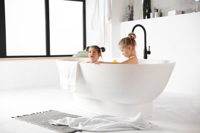 Cute little sisters taking bath together at home Photo of Cute little sisters taking bath together at home