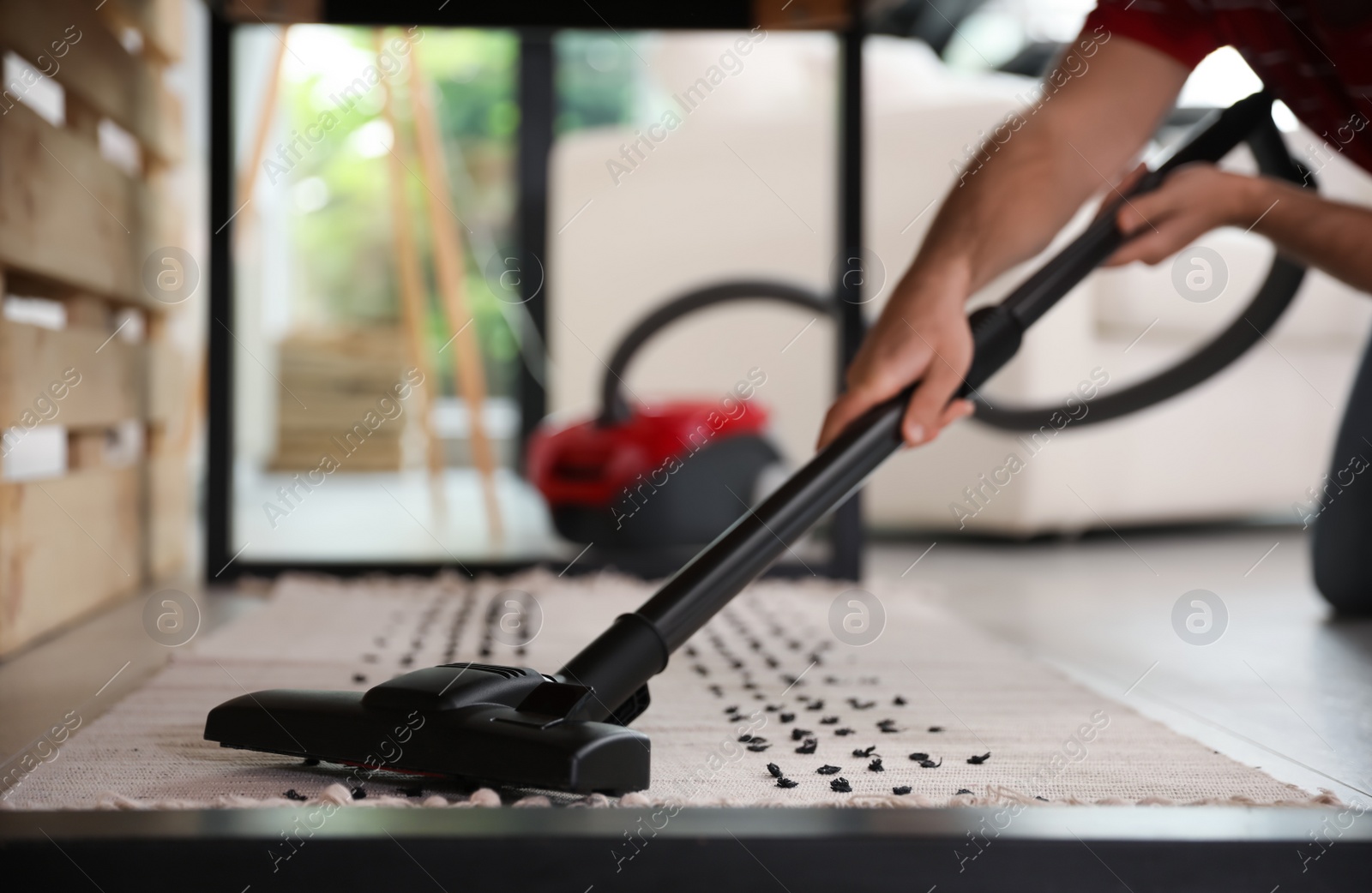 Young man using vacuum cleaner at home, closeup Photo of Young man using vacuum cleaner at home, closeup
