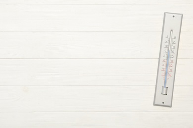 Weather thermometer on white wooden background, top view. Space for text Photo of Weather thermometer on white wooden background, top view. Space for text