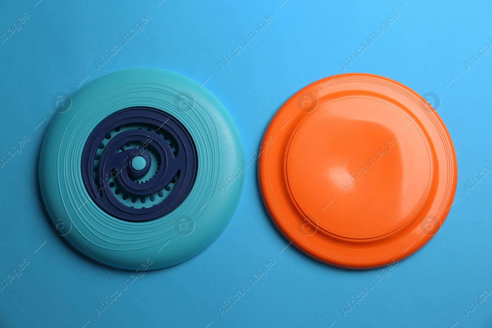 Plastic frisbee disks on light blue background, flat lay Photo of Plastic frisbee disks on light blue background, flat lay