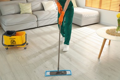 Woman cleaning floor with mop at home, closeup Photo of Woman cleaning floor with mop at home, closeup