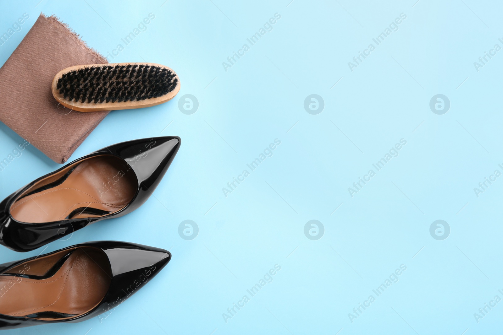 Photo of Flat lay composition with shoe care accessories and footwear on light blue background. Space for text