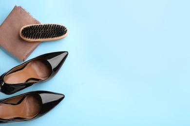 Photo of Flat lay composition with shoe care accessories and footwear on light blue background. Space for text