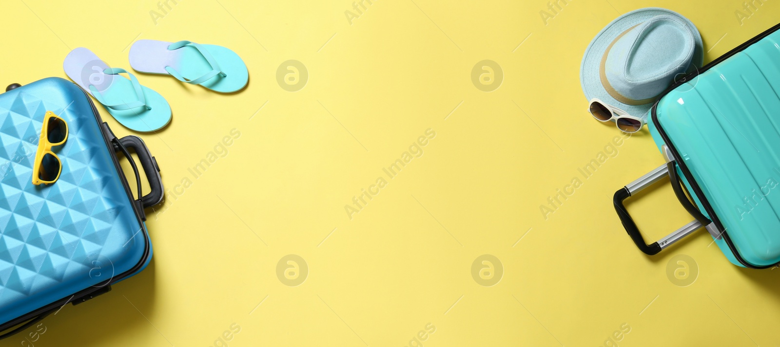 Flat lay composition with suitcases and space for text on yellow background Photo of Flat lay composition with suitcases and space for text on yellow background