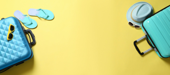 Photo of Flat lay composition with suitcases and space for text on yellow background