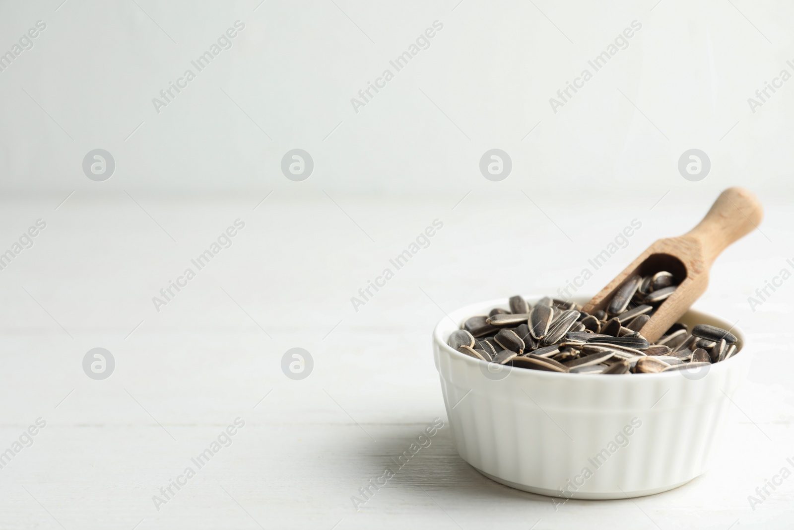 Organic sunflower seeds on white wooden table. Space for text Photo of Organic sunflower seeds on white wooden table. Space for text
