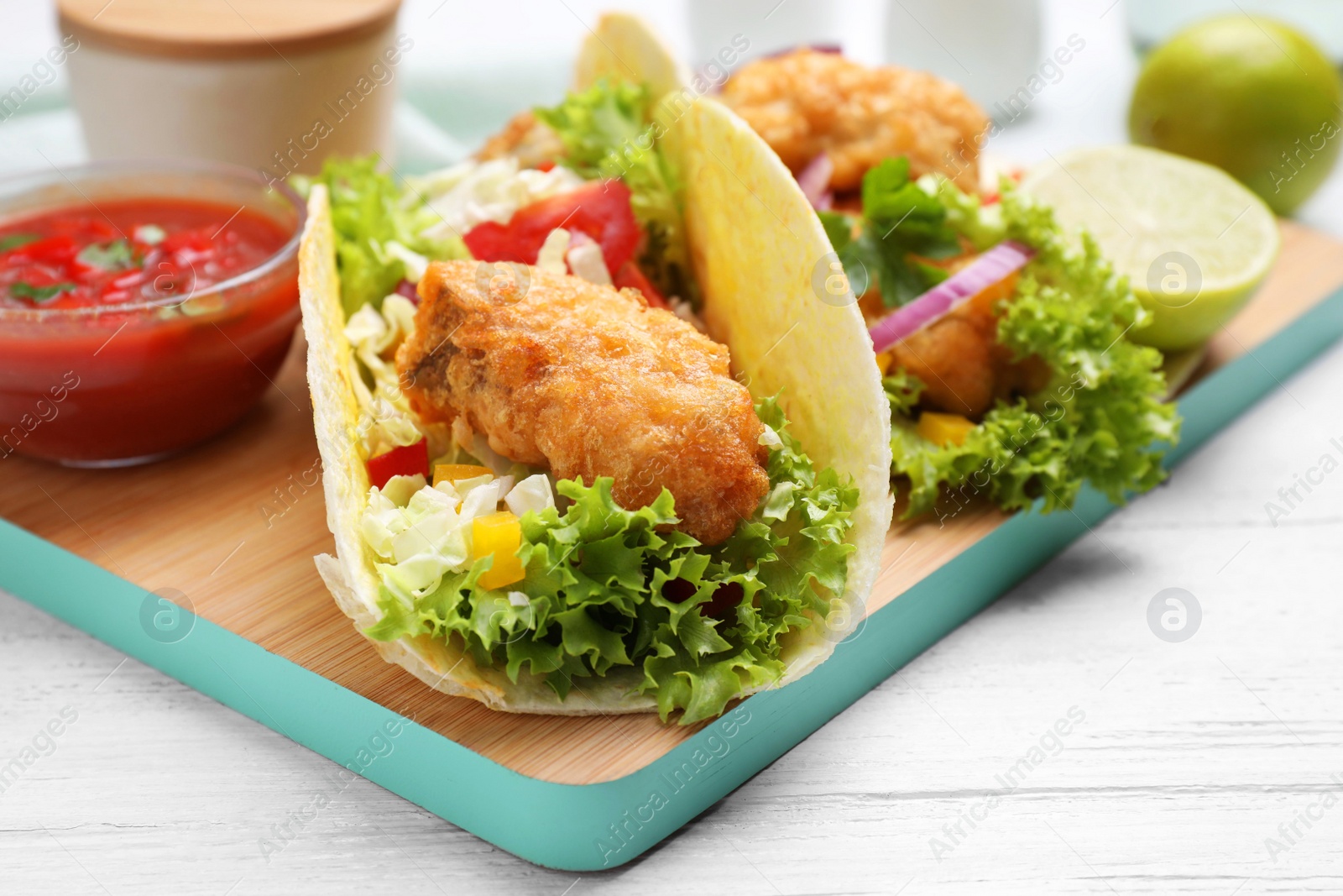 Delicious fish tacos served on white wooden table, closeup Photo of Delicious fish tacos served on white wooden table, closeup