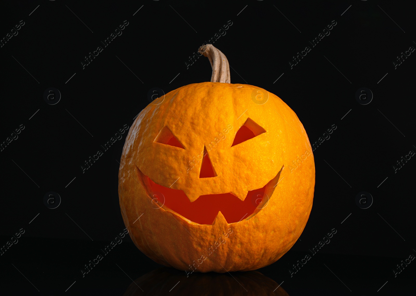 Pumpkin with scary face on black background. Halloween traditional decor Photo of Pumpkin with scary face on black background. Halloween traditional decor