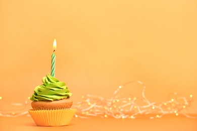 Birthday cupcake with candle on color background Photo of Birthday cupcake with candle on color background