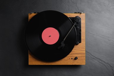 Modern vinyl record player with disc on black background, top view Photo of Modern vinyl record player with disc on black background, top view
