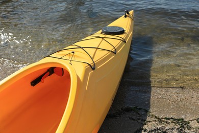 Yellow kayak on beach near river, closeup. Summer camp activity Photo of Yellow kayak on beach near river, closeup. Summer camp activity