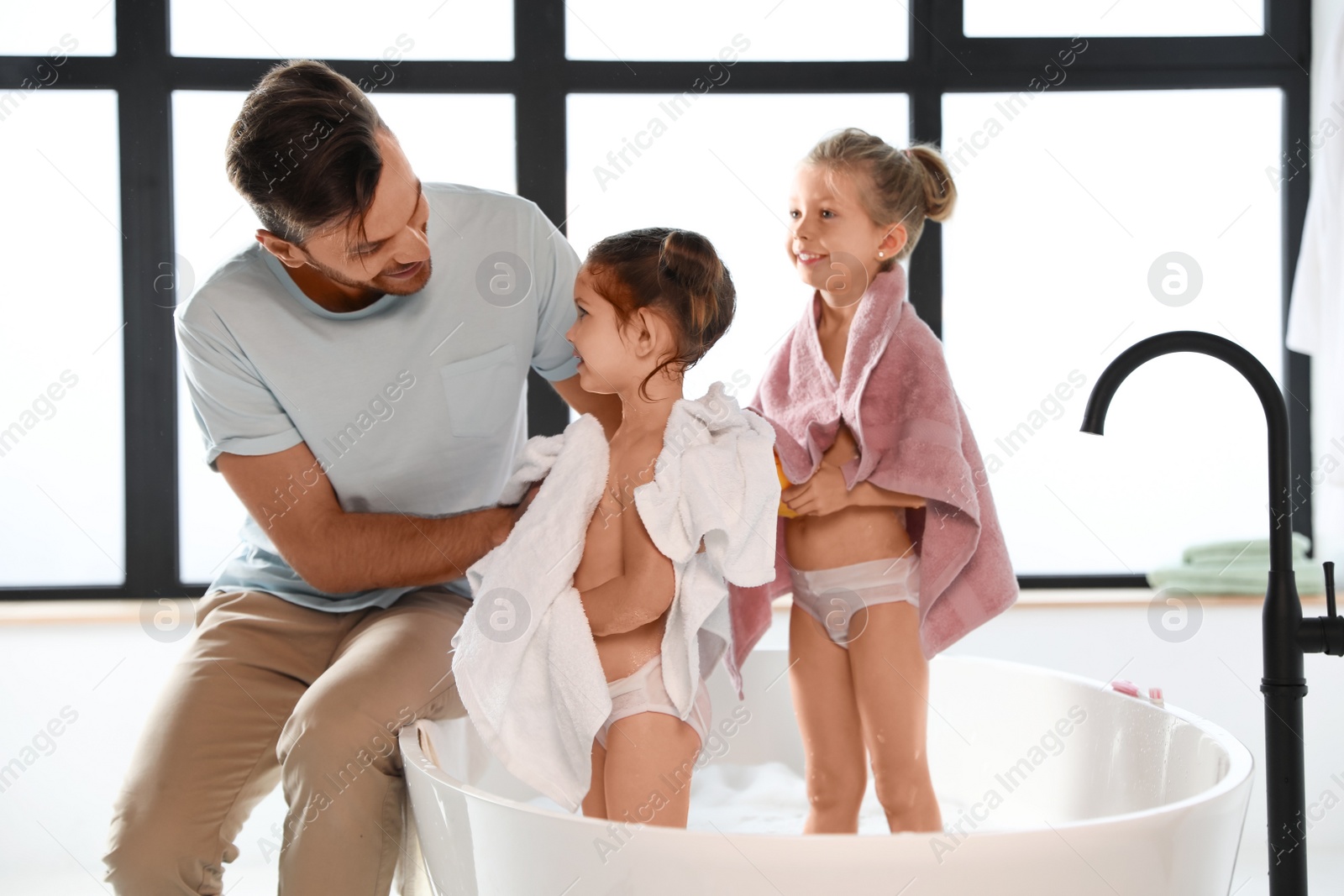 Young father with little daughters in bathroom Photo of Young father with little daughters in bathroom