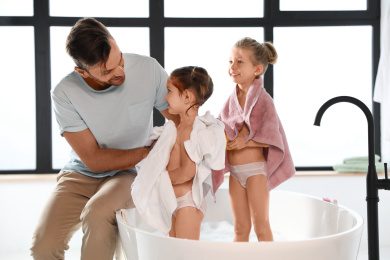 Young father with little daughters in bathroom Photo of Young father with little daughters in bathroom