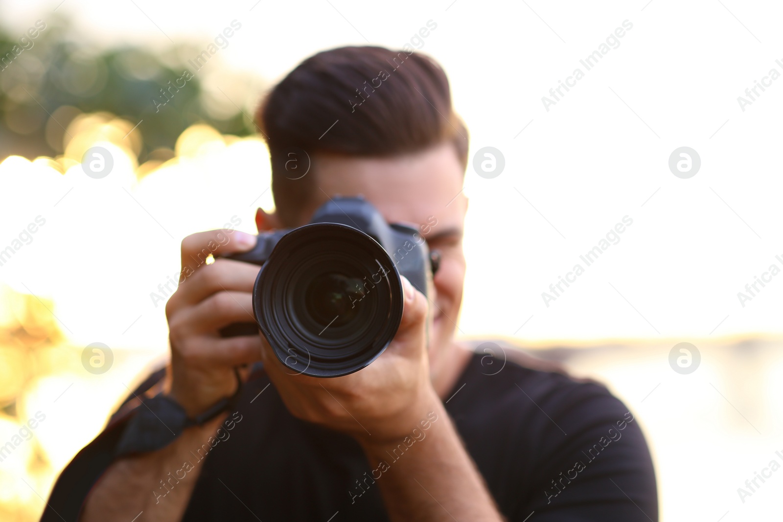 Photographer taking picture with professional camera in countryside, focus on lens Photo of Photographer taking picture with professional camera in countryside, focus on lens