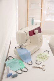 Sewing machine with cloth mask on table indoors Photo of Sewing machine with cloth mask on table indoors