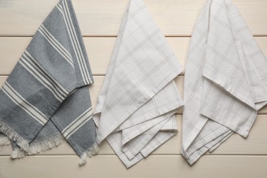 Different kitchen towels hanging on white wooden wall Photo of Different kitchen towels hanging on white wooden wall