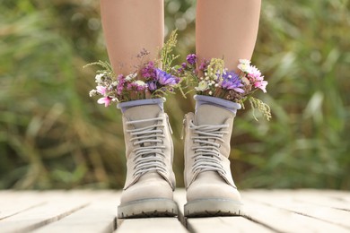 Woman standing on wooden pier with flowers in socks outdoors, closeup Photo of Woman standing on wooden pier with flowers in socks outdoors, closeup