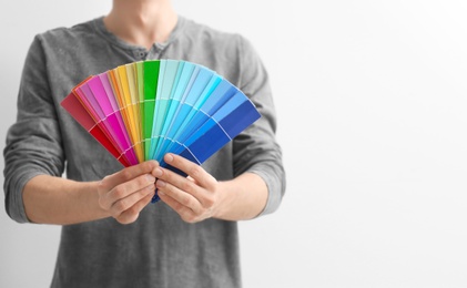 Male decorator holding color palette samples on white background Photo of Male decorator holding color palette samples on white background