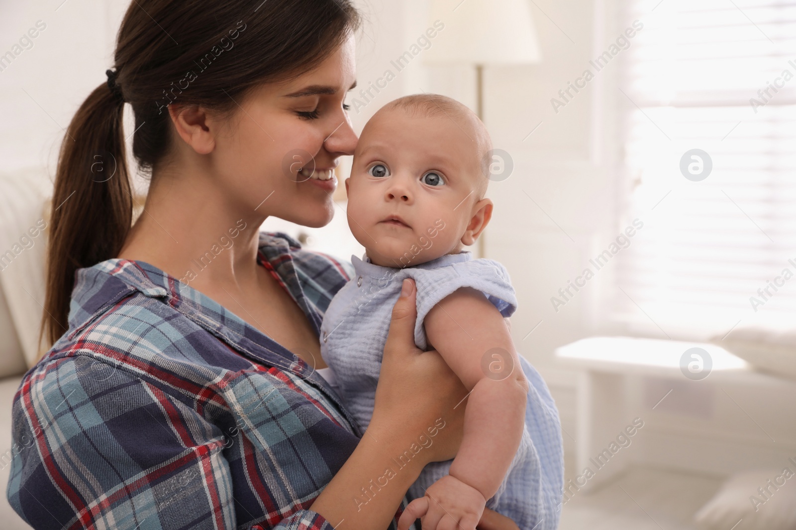 Happy young mother with her cute baby at home Photo of Happy young mother with her cute baby at home