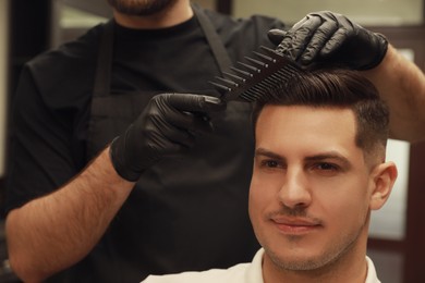 Professional hairdresser making stylish haircut in salon, closeup Photo of Professional hairdresser making stylish haircut in salon, closeup