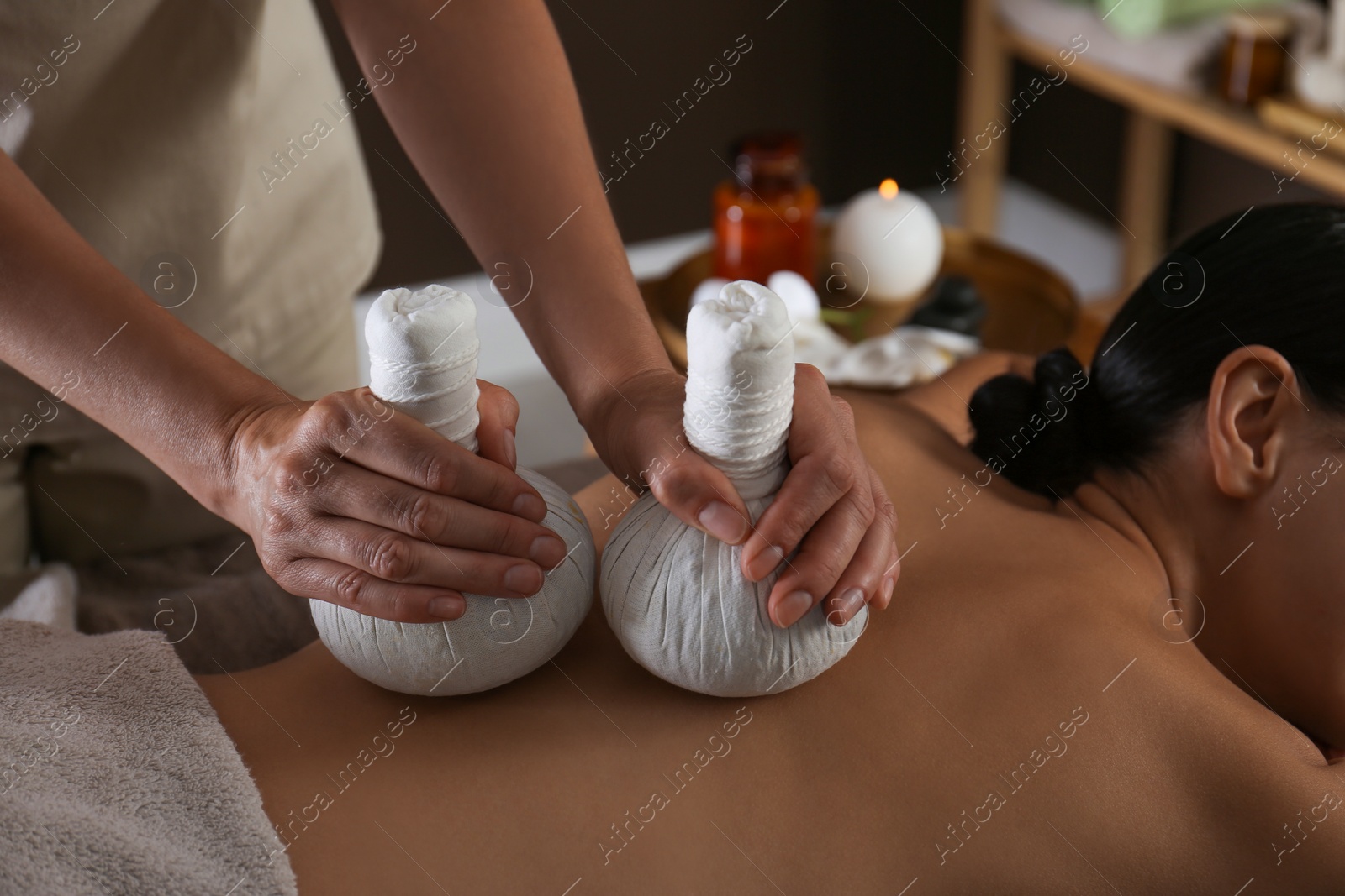 Young woman receiving herbal bag massage in spa salon, closeup Photo of Young woman receiving herbal bag massage in spa salon, closeup