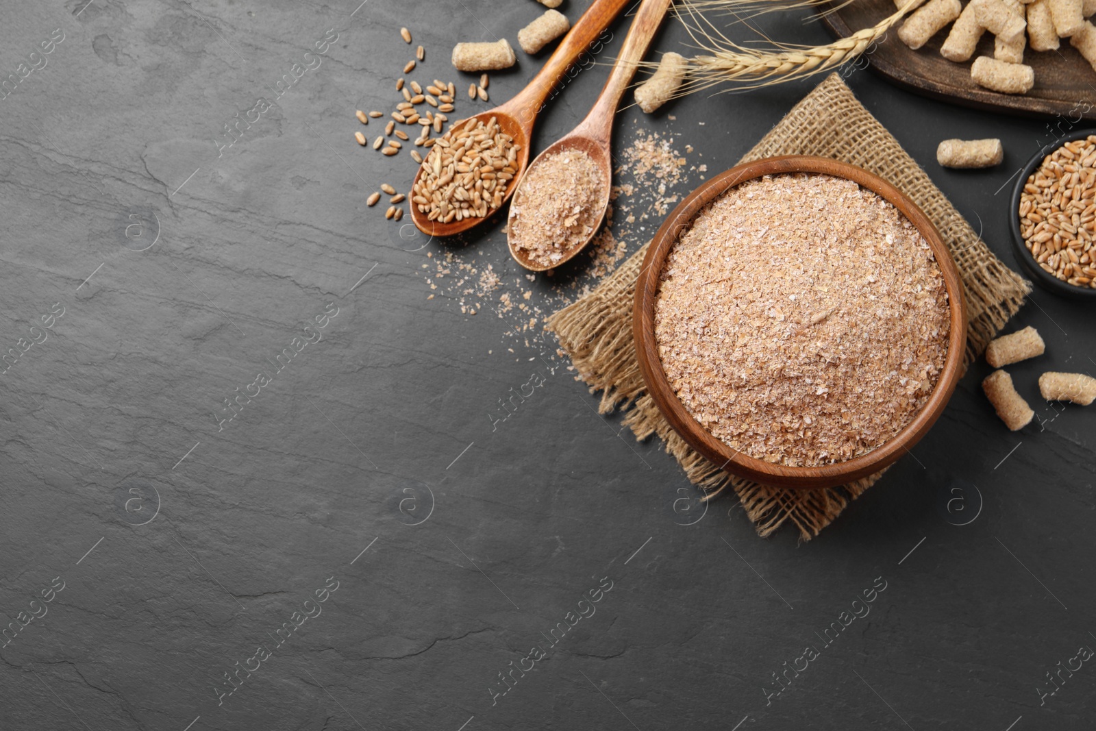 Wheat bran on black table, flat lay. Space for text Photo of Wheat bran on black table, flat lay. Space for text