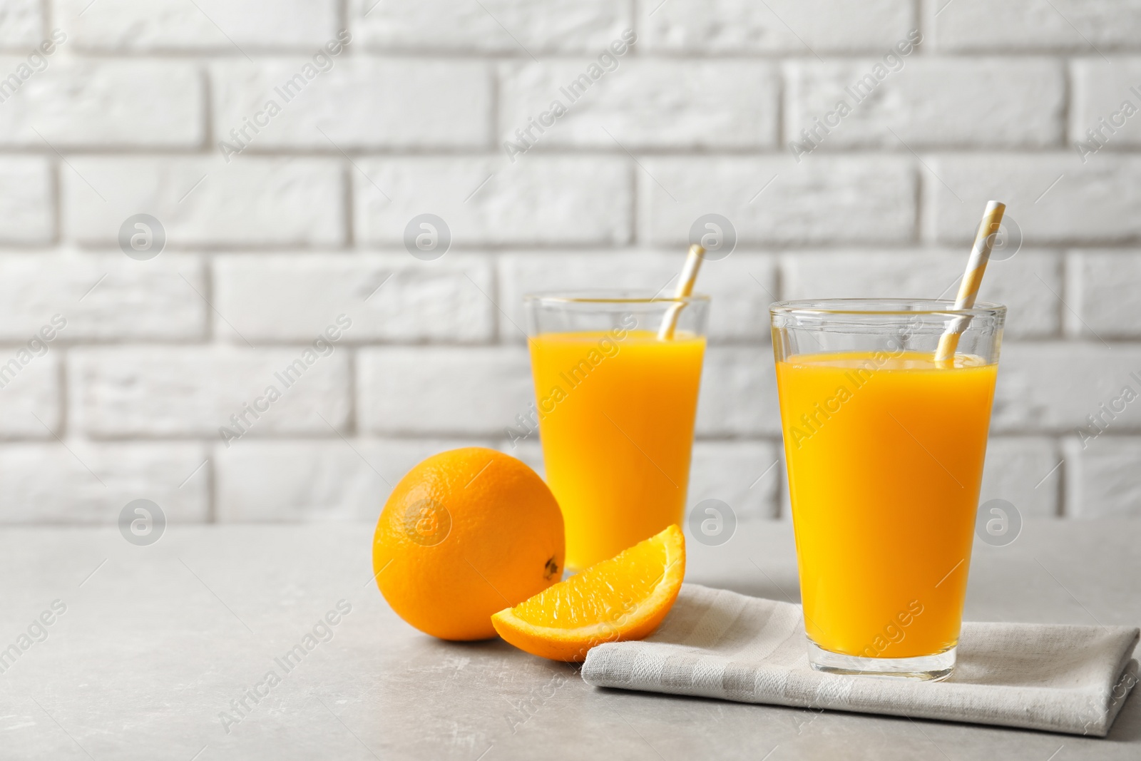 Glasses of orange juice and fresh fruits on table Photo of Glasses of orange juice and fresh fruits on table