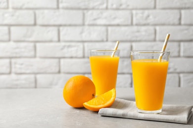 Glasses of orange juice and fresh fruits on table Photo of Glasses of orange juice and fresh fruits on table