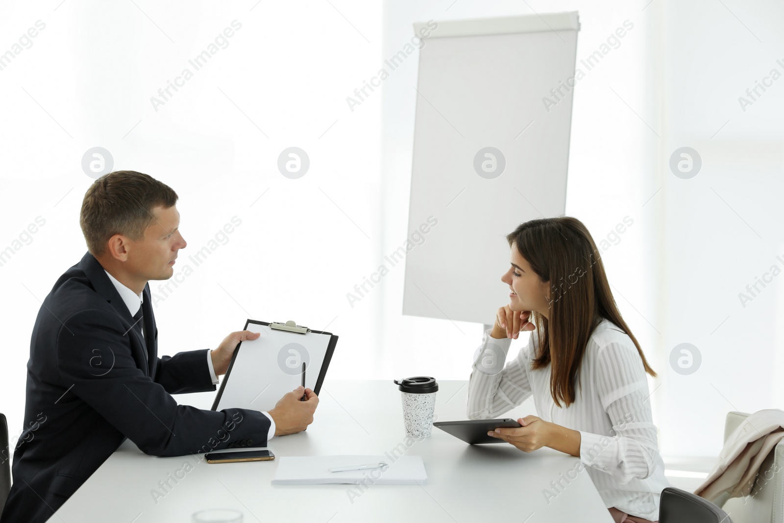 Office employees talking at table during meeting Photo of Office employees talking at table during meeting