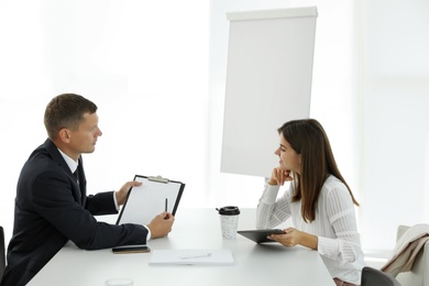 Office employees talking at table during meeting Photo of Office employees talking at table during meeting