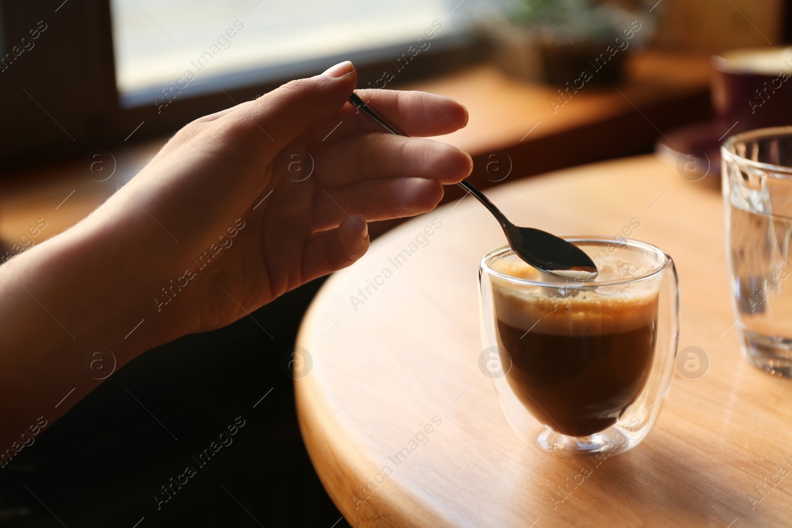 Woman with aromatic coffee at table in cafe, closeup Photo of Woman with aromatic coffee at table in cafe, closeup