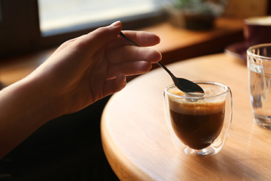 Woman with aromatic coffee at table in cafe, closeup Photo of Woman with aromatic coffee at table in cafe, closeup