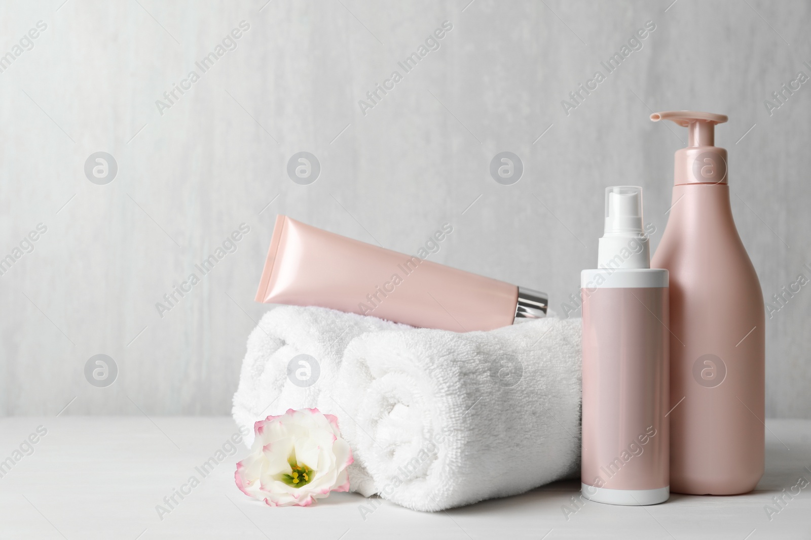 Different hair products, towel and comb on white wooden table Photo of Different hair products, towel and comb on white wooden table