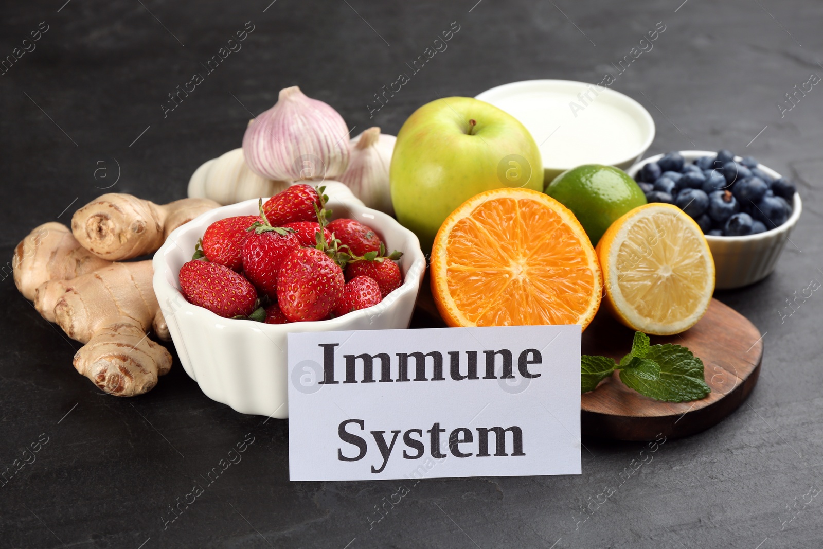 Card with phrase Immune System and fresh products on dark grey background Photo of Card with phrase Immune System and fresh products on dark grey background