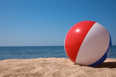 Colorful inflatable ball on sandy beach. Space for text Photo of Colorful inflatable ball on sandy beach. Space for text