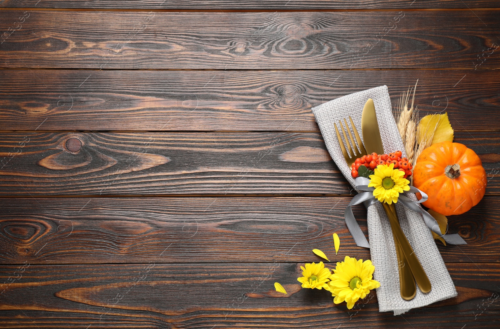 Cutlery and autumn decor on wooden table, flat lay with space for text. Thanksgiving Day celebration Photo of Cutlery and autumn decor on wooden table, flat lay with space for text. Thanksgiving Day celebration