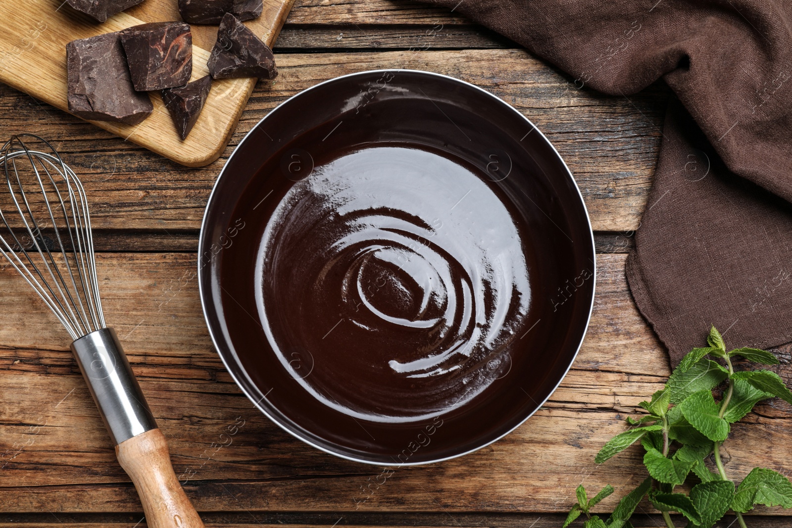 Delicious chocolate cream, whisk and mint on wooden table, flat lay Photo of Delicious chocolate cream, whisk and mint on wooden table, flat lay