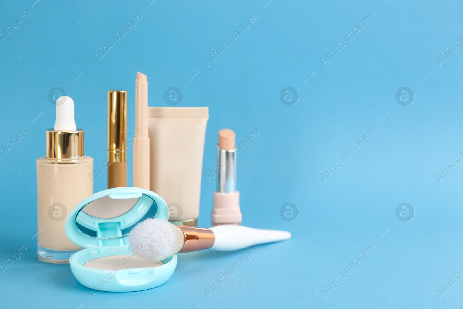 Foundation makeup products on light blue background, space for text. Decorative cosmetics Photo of Foundation makeup products on light blue background, space for text. Decorative cosmetics