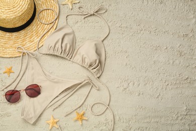 Flat lay composition with stylish bikini on sand. Space for text Photo of Flat lay composition with stylish bikini on sand. Space for text