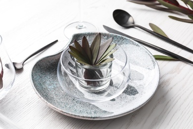 Elegant table setting with floral decor on white wooden background Photo of Elegant table setting with floral decor on white wooden background