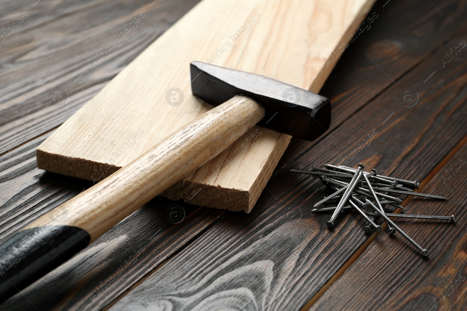 Hammer and metal nails on wooden table Photo of Hammer and metal nails on wooden table