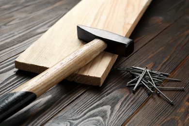 Hammer and metal nails on wooden table Photo of Hammer and metal nails on wooden table