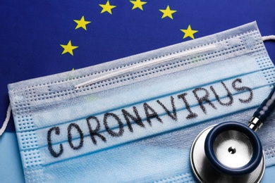 European Union flag, protective mask and stethoscope on light blue background, closeup. Coronavirus outbreak Photo of European Union flag, protective mask and stethoscope on light blue background, closeup. Coronavirus outbreak