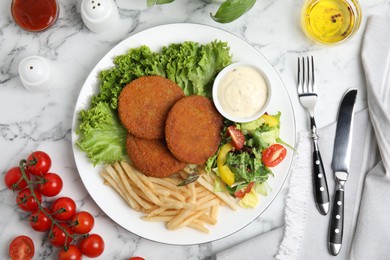 Delicious fried breaded cutlets with garnish served on white marble table, flat lay Photo of Delicious fried breaded cutlets with garnish served on white marble table, flat lay